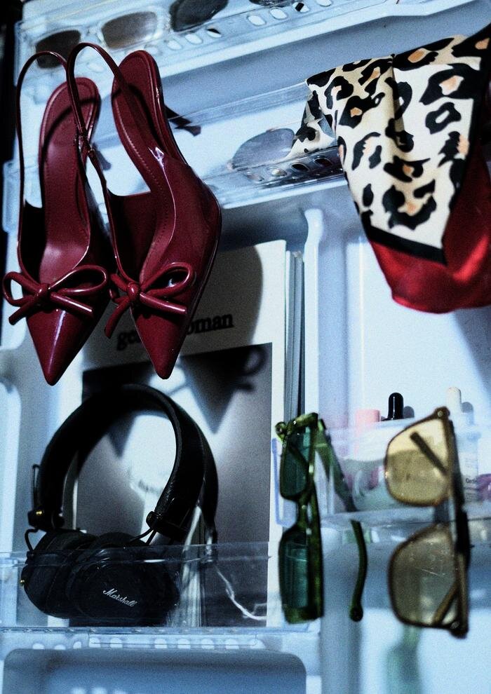 Red bow heels, headphones and sunglasses styled inside a fridge