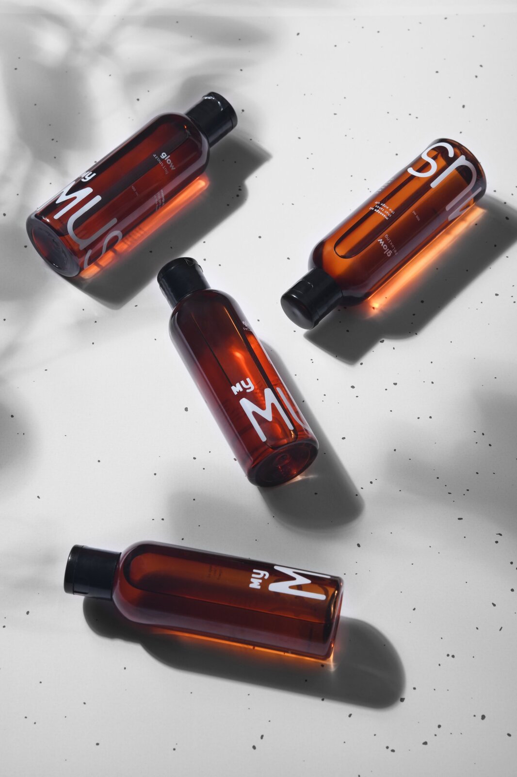 Amber bottles in hard light with leaf shadows